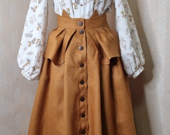May include: A brown linen skirt with a high waist and a button-up front. The skirt has a ruffle at the waist and is midi length. The skirt is paired with a white blouse with a floral print.