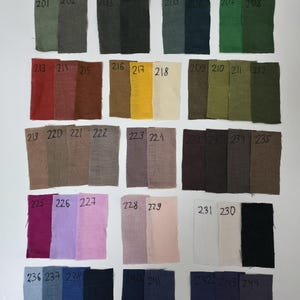 May include: A colour chart of 100% linen fabric swatches in various shades of green, brown, yellow, beige, grey, pink, red, blue, and black. The swatches are labelled with numbers from 201 to 244. The text "100% linen 180-200 mkg" is at the top of the chart.