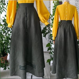 May include: A long, olive-green skirt with a high waist and decorative vertical stitching. The skirt features a subtle wave design near the hem. Paired with a yellow blouse with long, puffed sleeves and a high collar, creating a vintage aesthetic.