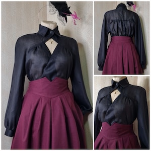 Op de afbeelding: Een zwart blouse met een V-hals en een bordeauxrode rok. De blouse is gemaakt van een doorschijnende, bijna doorzichtige stof. De rok is A-lijn en heeft een hoge taille.