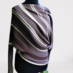 May include: A brown and white striped sweater with a loose fit and long sleeves. The sweater is made of a soft, stretchy material and has a unique, draped design.
