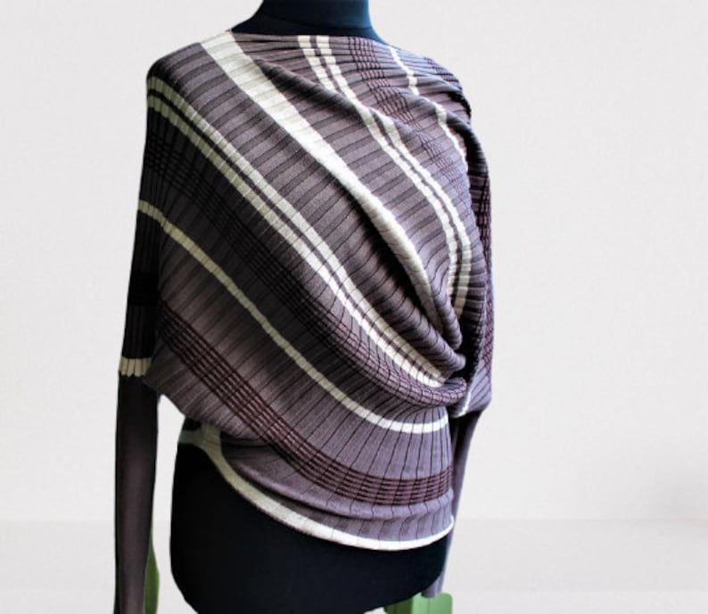 May include: A brown and white striped sweater with a loose fit and long sleeves. The sweater is made of a soft, stretchy material and has a unique, draped design.