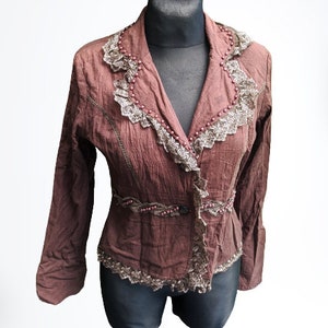 May include: A brown, long-sleeved, fitted jacket with lace trim and beaded accents.