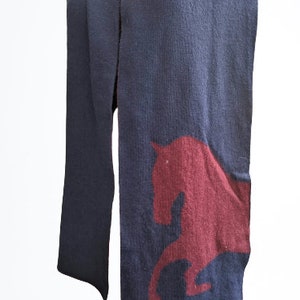 May include: A navy blue scarf with a maroon horse silhouette design.