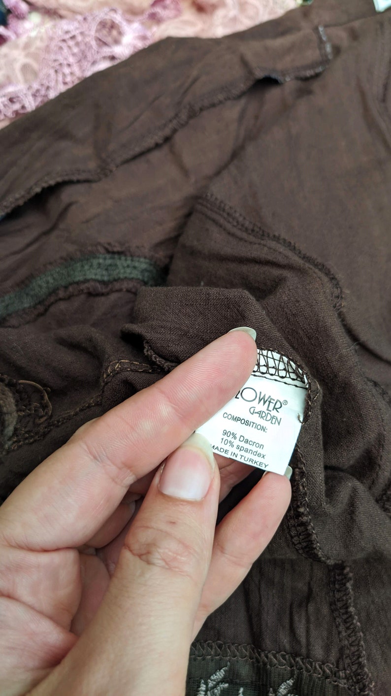 May include: A white tag with black text that reads "FLOWER GARDEN" and "COMPOSITION: 90% Dacron 10% spandex MADE IN TURKEY".