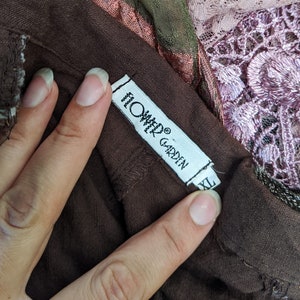 May include: A brown garment tag with white text that reads "Onyx Garden" and "Hand Woven" with a size label that reads "XL".