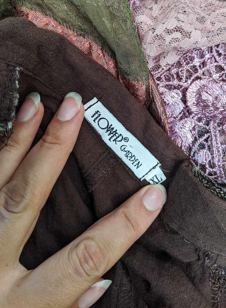 May include: A brown garment tag with white text that reads "Onyx Garden" and "Hand Woven" with a size label that reads "XL".