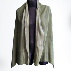 May include: A green scarf with a white stripe down the center. The scarf is folded in half and draped over a mannequin.
