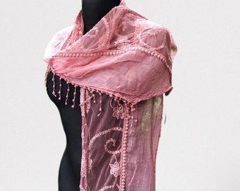 May include: A pink sheer scarf with delicate lace trim and floral embroidery. The scarf is draped over a mannequin.