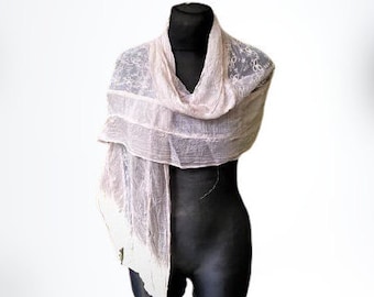 May include: A delicate, sheer pink scarf with a lace pattern. The scarf is draped over a mannequin's shoulders and is made of a lightweight fabric.