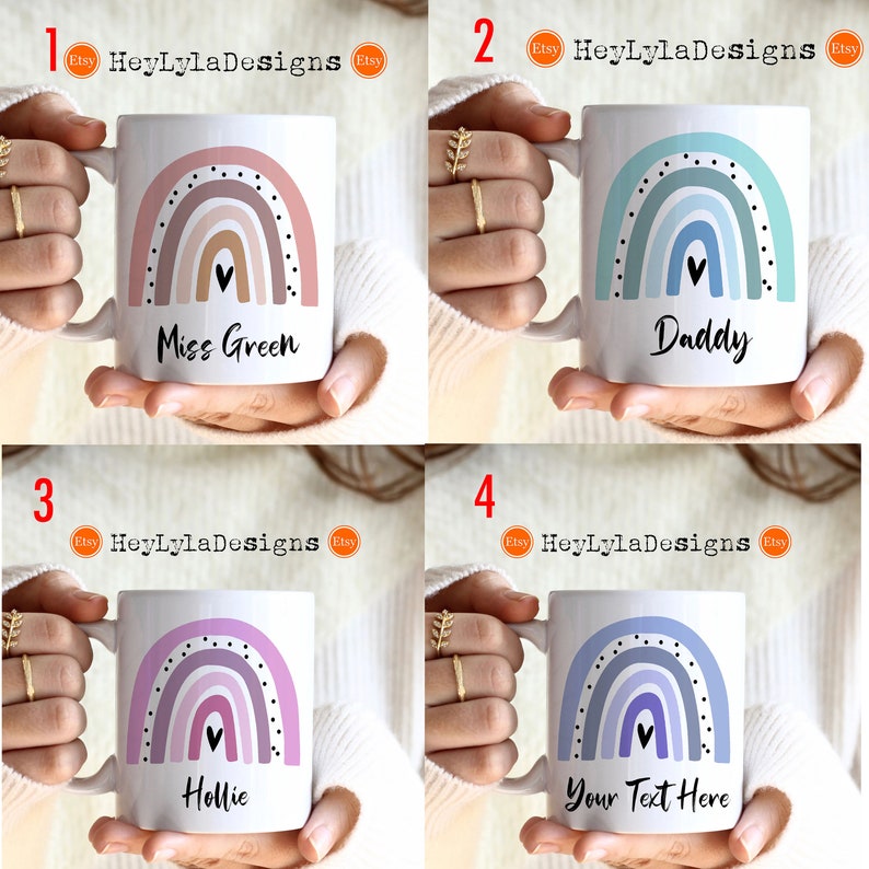 K&ouml;nnte beinhalten: Vier wei&szlig;e Keramikbecher mit Regenbogen-Designs und personalisiertem Text. Die Becher zeigen einen mehrfarbigen Regenbogen mit einem Herzen oben und schwarzen Punkten um den Regenbogen herum. Der Text auf den Bechern lautet "Miss Green", "Daddy", "Hollie" und "Your Text Here".