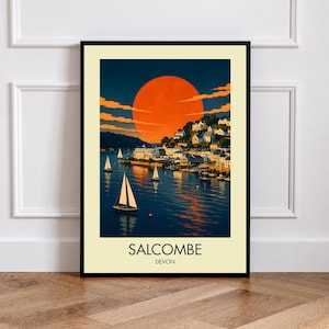 Könnte beinhalten: Ein gerahmter Kunstdruck mit einer Küstenszene von Salcombe, Devon, mit einer großen orangefarbenen Sonne, die über einem mit Segelbooten gefüllten Hafen untergeht. Die Stadt ist an einem Hang mit weißen Gebäuden erbaut. Der Text SALCOMBE DEVON steht unten.