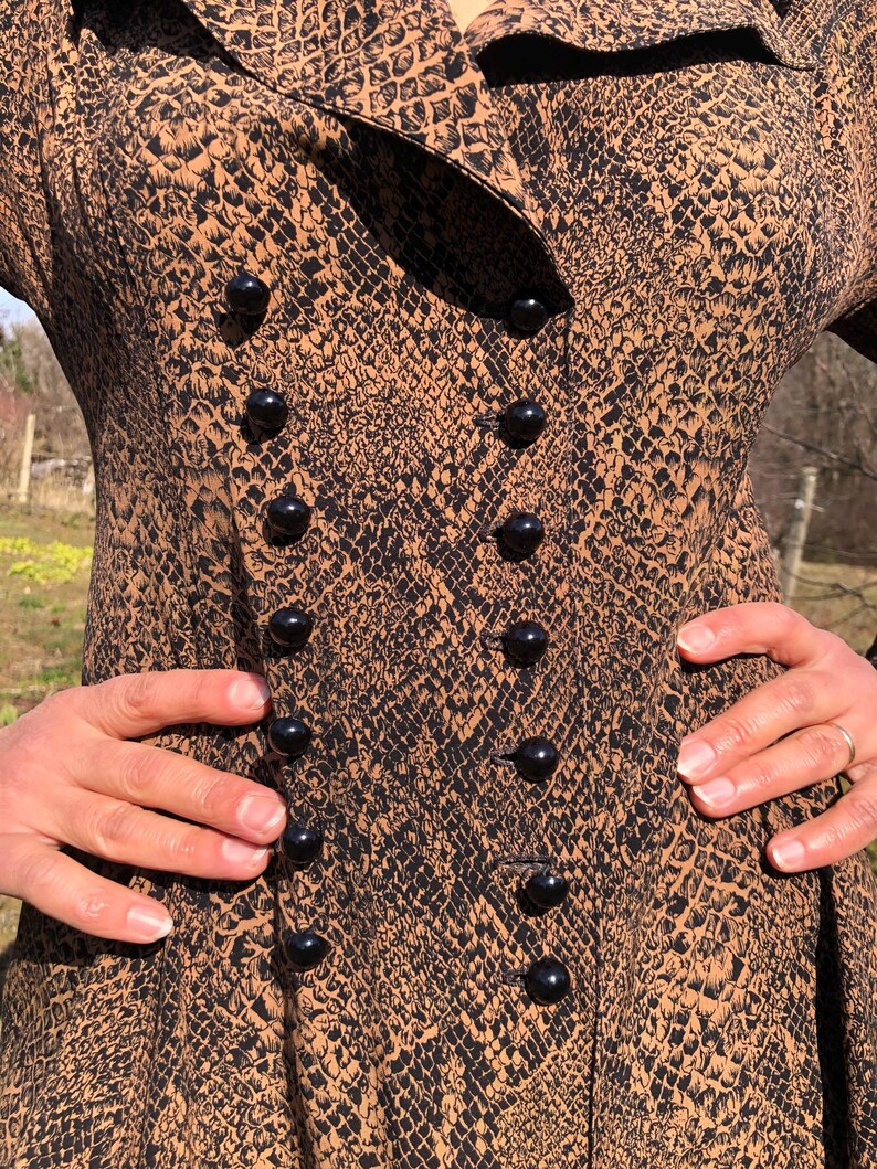 May include: A brown and black snakeskin print dress with a double row of black buttons down the front.