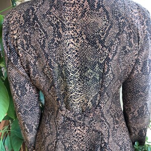 May include: A long-sleeved shirt with a snakeskin print in shades of brown and black.
