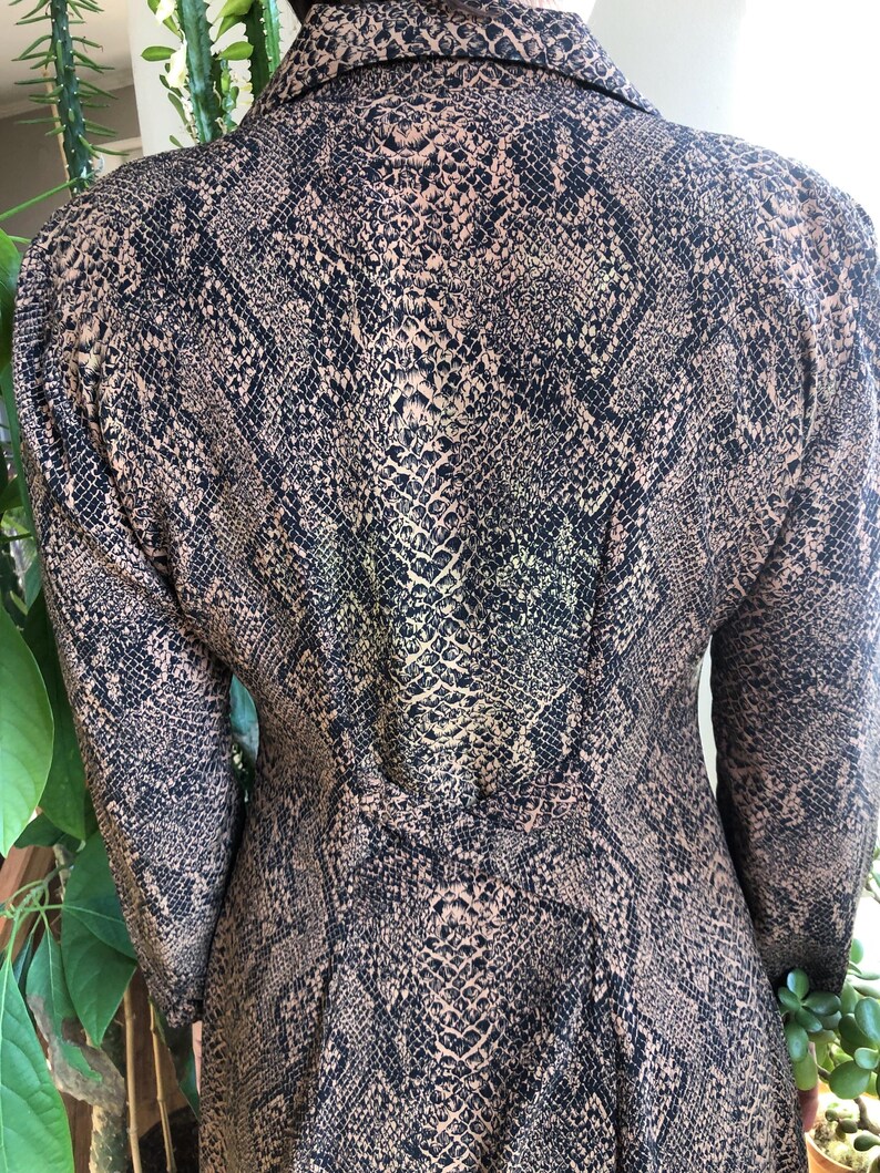 May include: A long-sleeved shirt with a snakeskin print in shades of brown and black.