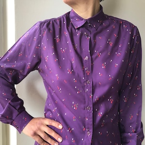 Vintage 70s purple women’s blouse with colorful drops print. Long sleeve collared front buttoned shirt. M size