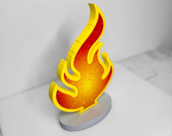 Könnte beinhalten: Ein Holzpuzzle in Form einer Flamme. Das Puzzle besteht aus vielen kleinen Teilen, die zusammengefügt werden, um die Form einer Flamme zu bilden. Die Flamme ist in Gelb-, Orange- und Rottönen bemalt.