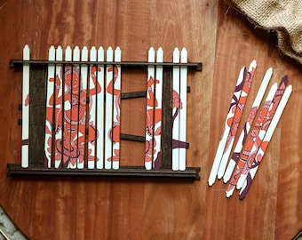 Könnte beinhalten: Ein Holzpuzzle mit einem Rahmen und einzelnen Teilen. Die Teile sind mit einem weißen Hintergrund und einer bunten Illustration einer Frau im traditionellen indischen Stil verziert. Das Puzzle wird zu einer fensterartigen Form zusammengesetzt.