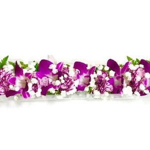 Puede incluir: Un collar de flores morado y blanco con orqu&iacute;deas y claveles.