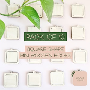 Może przedstawiać: Opakowanie 10 mini drewnianych obręczy w kształcie kwadratu. Obręcze wykonane są z naturalnego drewna i mają jasnobrązowy kolor. Obręcze są ułożone w siatkę na białym tle. Tekst "PACK OF 10" jest napisany zielonymi literami na białym tle. Tekst "SQUARE SHAPE MINI WOODEN HOOPS" jest napisany białymi literami na różowym tle. Tekst "HOOPS n' more" jest napisany czarnymi literami na różowym tle.
