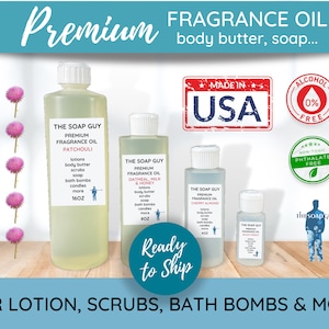 May include: Four clear glass bottles of fragrance oil with white lids and labels. The labels read "The Soap Guy Premium Fragrance Oil" with different scents: Patchouli, Oatmeal, Milk & Honey, Cherry Almond, and Black Pomegranate. The bottles are on a wooden surface with a blue background. The text "Ready to Ship" is in a white circle with a blue border. The text "For Lotion, Scrubs, Bath Bombs & More" is at the bottom of the image.