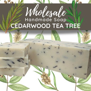 May include: A bar of handmade cedarwood and tea tree soap. The soap is white with black flecks and is shown in a stack of three bars and a larger bar.