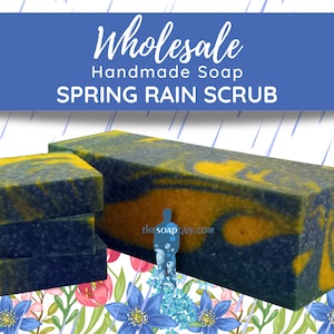 May include: Wholesale handmade soap bars in a blue and yellow swirl pattern with a spring rain scrub scent. The soap bars are stacked on top of each other and are sitting on a floral background.