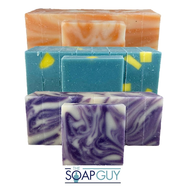 May include: A stack of handmade soaps in various colors and designs. The soaps include orange, blue with yellow accents, and purple with white swirls. The Soap Guy logo is at the bottom.