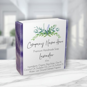 May include: A bar of lavender-scented handmade soap with a purple swirl design. The soap is packaged in a white box with a floral design and the text "Company Name Here", "Premium Handmade Soap", "Lavender", "4.5oz", and a list of ingredients.