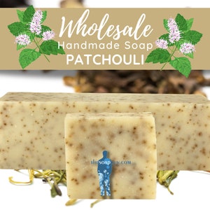May include: Two bars of handmade patchouli soap, one large and one small, on a white surface with dried herbs and flowers. The soap is light green with brown flecks. The text "Wholesale Handmade Soap PATCHOULI" is on a brown banner above the soap.