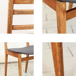 K&ouml;nnte beinhalten: Ein Holzstuhl mit einem grauen Stoffbezug. Der Stuhl hat ein schlichtes Design mit vier Beinen und einer Lattenr&uuml;cklehne. Der Stuhl ist in gutem Zustand, weist aber Gebrauchsspuren auf.