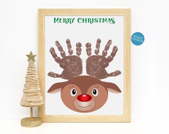 May include: A printable Christmas craft featuring a reindeer with handprint antlers. The reindeer has a red nose and a brown face. The text "Merry Christmas" is printed in green at the top of the page.