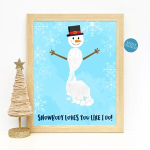 May include: A printable art print featuring a snowman made with a footprint. The snowman is wearing a black top hat with a red band and has a carrot nose. The background is blue with white snowflakes. The text "Snowbody loves you like I do!" is at the bottom of the print.