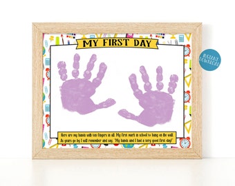 May include: A printable first day of school sign with a yellow banner that says "My First Day". The sign has a white background with a colorful school-themed border. Two purple handprints are in the center of the sign. The text below the handprints reads: "Here are my hands with ten fingers in all. My first mark in school to hang on the wall. As years go by I will remember and say, "My hands and I had a very good first day!"