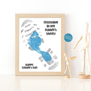 May include: A printable Father's Day card with a blue footprint inside a gray footprint. The text reads "Following in my Daddy's shoes!" and "Happy Father's Day".