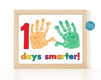 May include: A printable sign with a large red number 1, two handprints, one orange and one green, and the text "days smarter!" in rainbow colors.