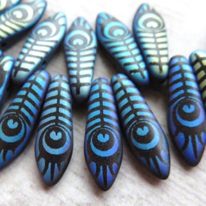 May include: A strand of blue and green iridescent glass beads with a peacock feather design. The beads are shaped like teardrops and have a black background.