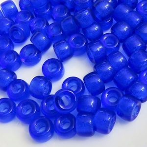 May include: A large quantity of bright blue plastic beads. The beads are round with a hole in the center. They are perfect for crafting.