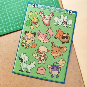 Pode incluir: Uma folha de adesivos com vários personagens de desenhos animados em um fundo verde. A folha é rotulada como "NORMAL TYPE!!!" e inclui uma variedade de criaturas coloridas. A folha de adesivos está em uma base de corte.