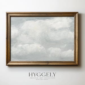 May include: A framed painting depicting a cloudy sky in shades of grey and white. The painting is presented in a plain wooden frame.