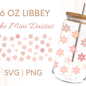 May include: A 16 oz. glass jar with a wooden lid and a straw. The jar is decorated with a pattern of pink and peach daisies. The text "16 OZ LIBBEY Boho Mini Daisies SVG | PNG" is printed on a white background.