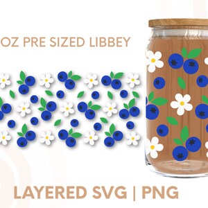 May include: A 16 ounce pre-sized glass jar with a wooden lid, decorated with a pattern of blue blueberries and white flowers. The jar is sitting on a white background. The text "16 OZ PRE SIZED LIBBEY" is at the top of the image. The text "LAYERED SVG | PNG" is at the bottom of the image.