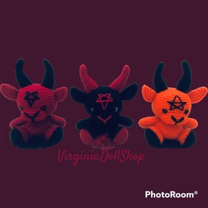 May include: Three crocheted plush dolls featuring horned creatures with black eyes and a pentagram stitched on their foreheads. The left doll is red with black horns and feet, the center is black with red horns, and the right is orange with black horns.