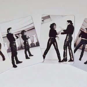 May include: Four rectangular trading cards featuring black and white photographs of Michael Jackson and Janet Jackson. Each card displays the pair wearing black long-sleeved tops and dark trousers, captured in various dance poses against a light background.