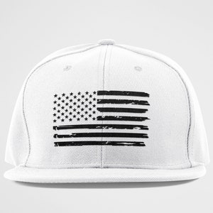 Peut inclure: Une casquette de baseball blanche avec un motif de drapeau am&eacute;ricain noir d&eacute;lav&eacute;.