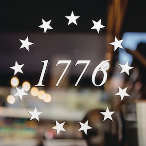K&ouml;nnte beinhalten: Ein wei&szlig;er Kreis aus Sternen umgibt die Zahl 1776, ein bedeutendes Jahr in der amerikanischen Geschichte.