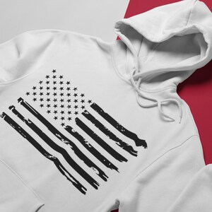 Peut inclure: Sweat-shirt &agrave; capuche blanc avec un motif de drapeau am&eacute;ricain noir d&eacute;lav&eacute;.