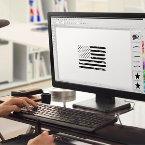 Peut inclure: Une personne con&ccedil;oit un graphique de drapeau am&eacute;ricain en d&eacute;tresse sur un ordinateur. Le drapeau est noir et blanc avec un effet grunge. Le logiciel de conception montre une vari&eacute;t&eacute; de coups de pinceau et d'&eacute;toiles.