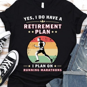 May include: Black t-shirt with a retro-style graphic of a runner. The text reads "YES, I DO HAVE A RETIREMENT PLAN I PLAN ON RUNNING MARATHONS".