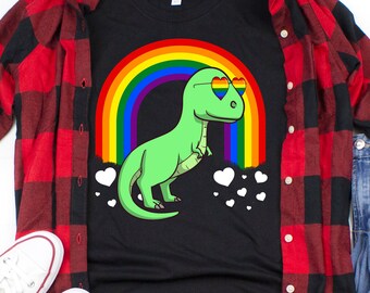 May include: A black t-shirt with a green dinosaur wearing rainbow heart sunglasses in front of a rainbow. White hearts are scattered around the dinosaur.